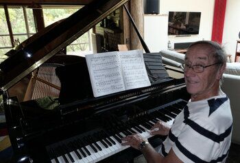 Russell Kelly plays his grand piano